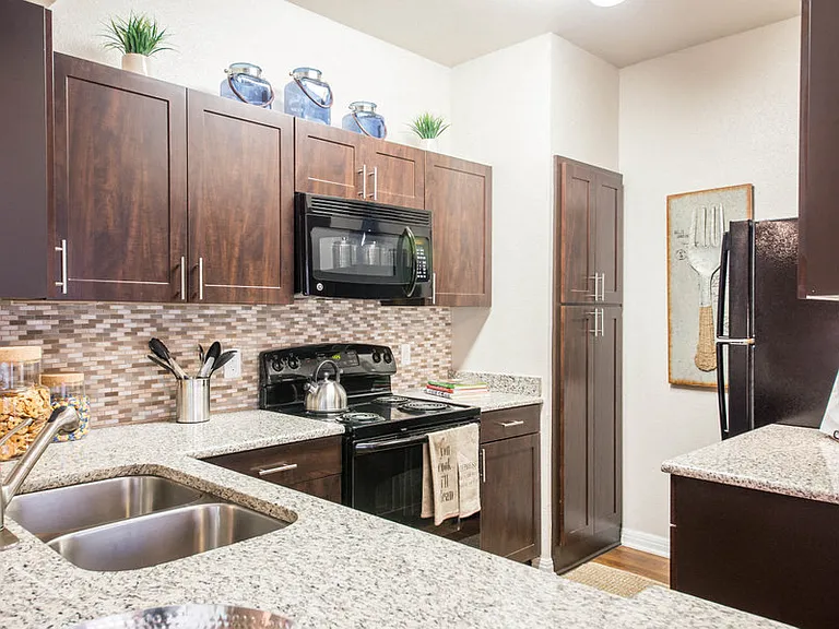 Austin TX Apartments for Rent - Large Kitchen Fully Equipped with Amenities Such As Fridge, Stove, and Microwave Also Featuring Plenty of Storage and Counter Space