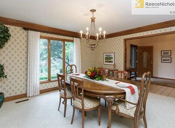 Spacious dining room has wood crown molding.
