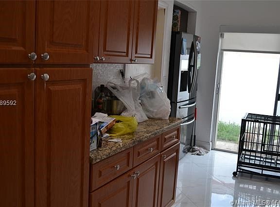 Kitchen with granite countertop and S/S appliances.