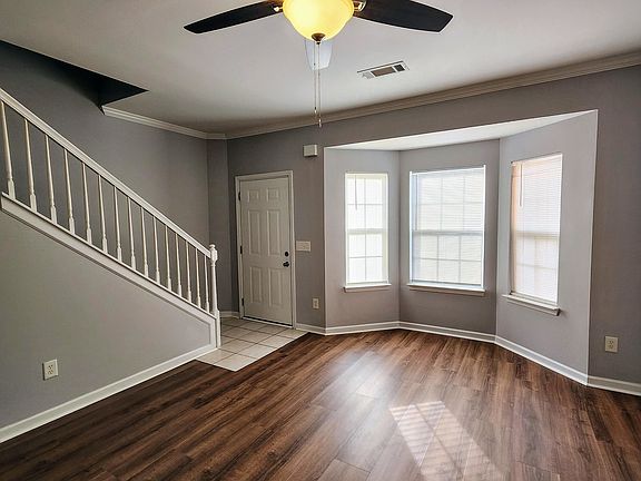 Living room showing entry door and bay windows