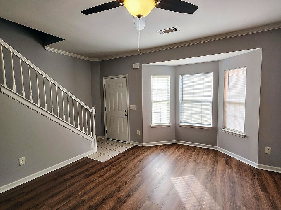 Living room showing entry door and bay windows