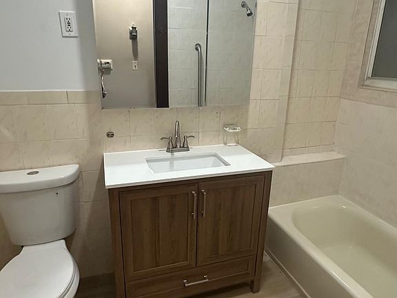 Newly furnished bathroom vanity, toilet, and floors.