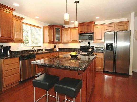 Gourmet kitchen w/granite slab, stainless steel appliances & custom cabinets