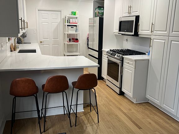 White Kitchen with great storage and white quartz countertops. Laundry room off of kitchen.