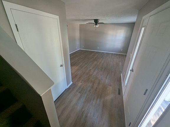 View from stairs coming down into Living Room and front door with coat closet