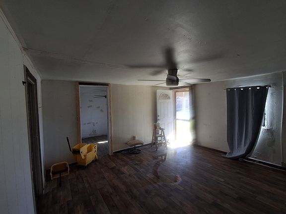 Other point of veiw of living room, showing the front door, hallway, and room that connect to the loving room