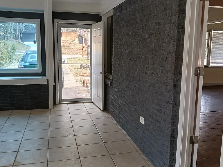 Large bonus room extends from driveway to the back deck. Door on right opens to kitchen.