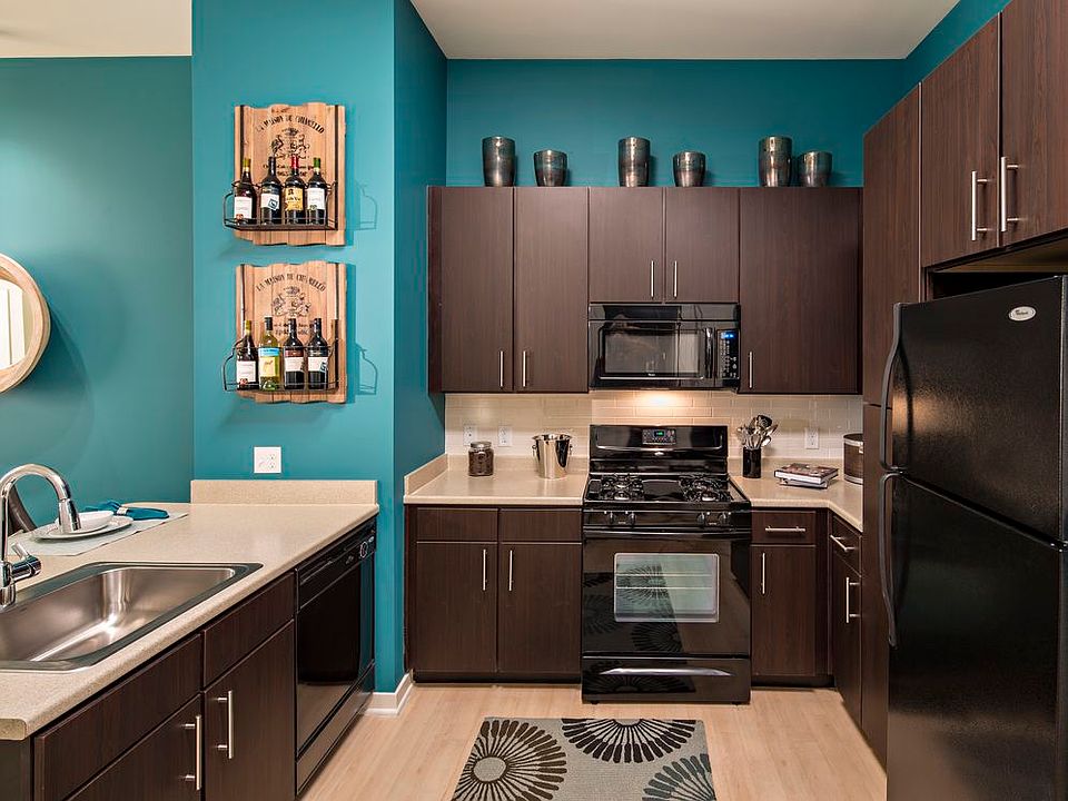 Classic Package II kitchen with black appliances, beige laminate countertops, dark brown cabinetry, white tile backsplash, and hard surface flooring
