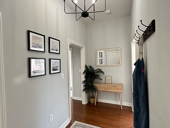 A well-lit entryway with hardwood flooring and high ceilings. The space connects seamlessly to other areas of the home, offering a practical yet welcoming passageway.