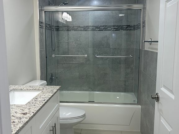 vanity with granite top ,tiled bathtub & shower