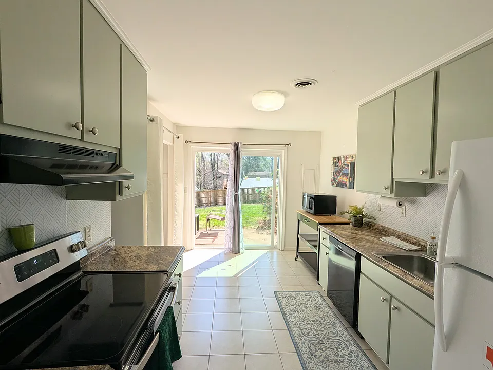 Big Kitchen opens to sunny patio. Sage green kitchen cabinets, updated appliances, dish washer, tile floors