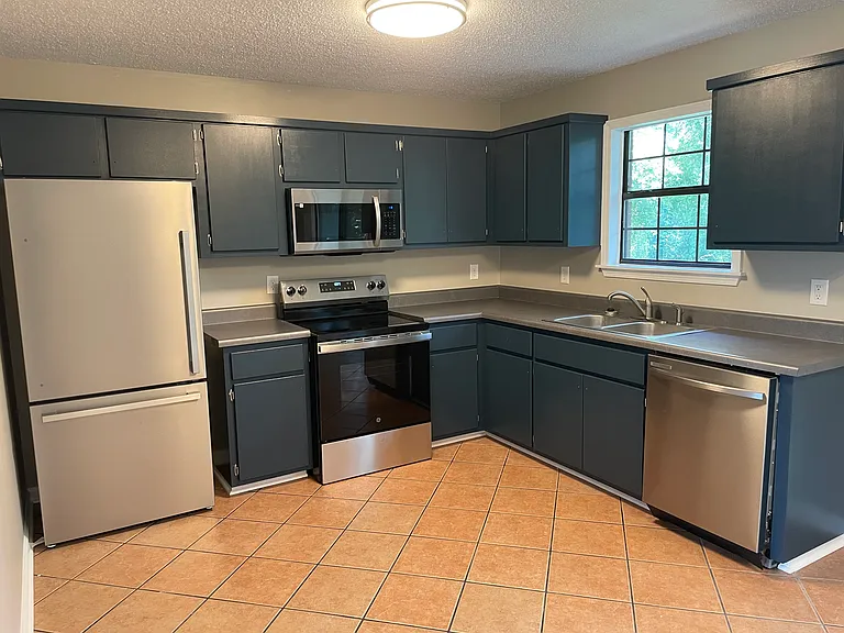 Updated kitchen with stainless steel appliances, tile floors, and loads of cabinet space