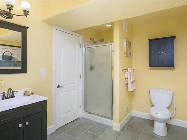 Basement bathroom with door leading to bedroom