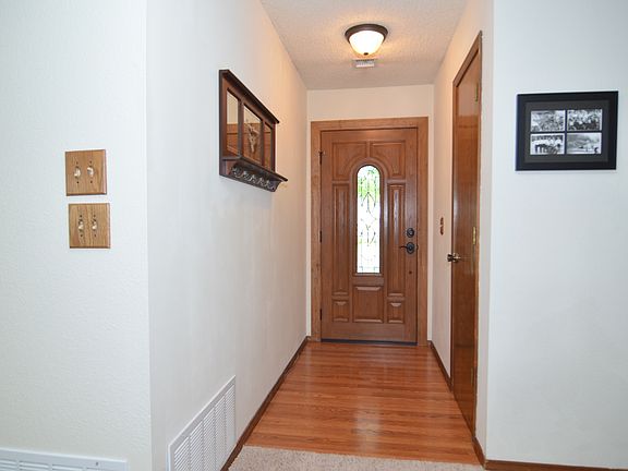 Wood floored entry with coat storage closet