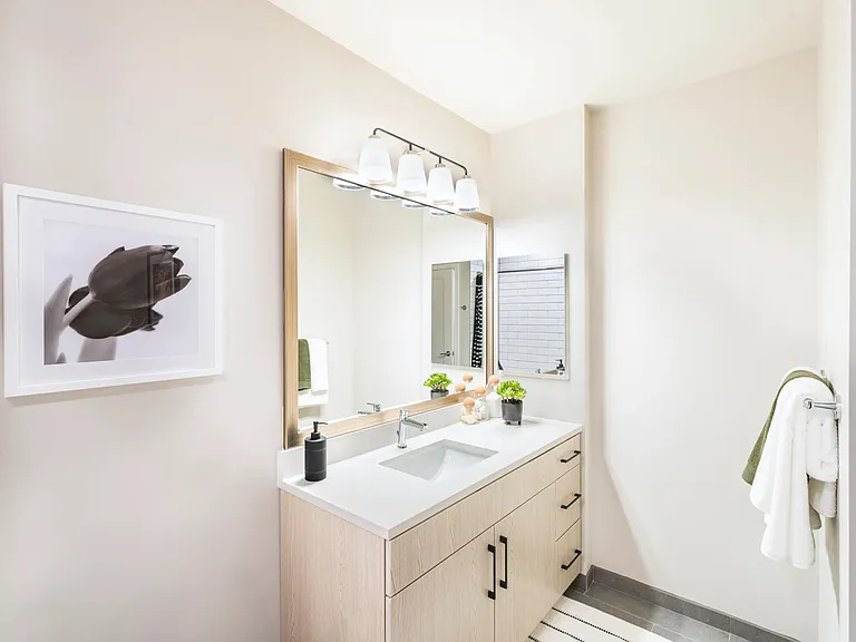 This bright and modern bathroom features quartz countertops, ample storage, and a clean, polished design for your daily routine.
