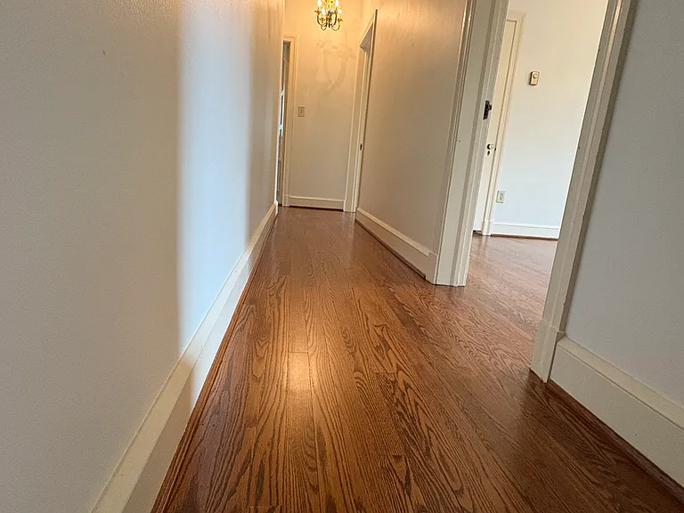 Upstairs hallway to 3 additional bedrooms and full bathroom. Floors redone in 2025 and walls and ceilings skimmed and painted in 2025