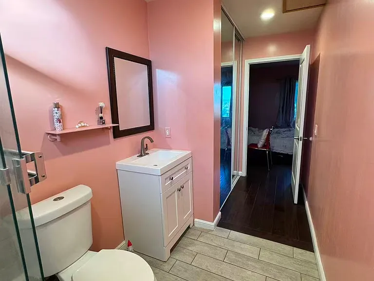 Inside of bathroom (includes a closet rolling door mirror), a tub, a shower, and clear glass walls. There's a door for privacy provided connecting the suite to the bathroom.