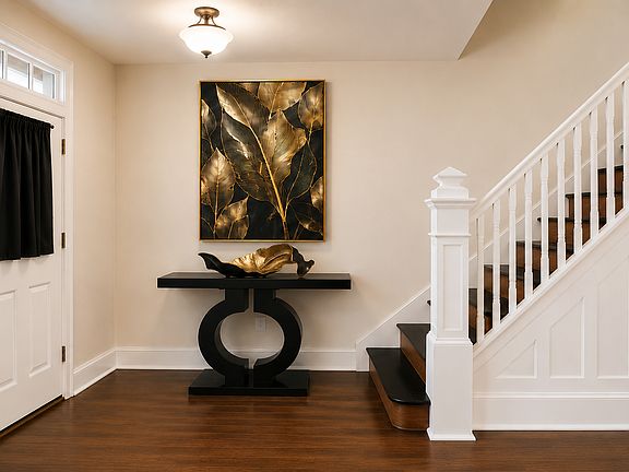 Modern,Traditional Foyer with Black & Gold Accents featuring Custom Stairs with Wood and Black Contrast.
