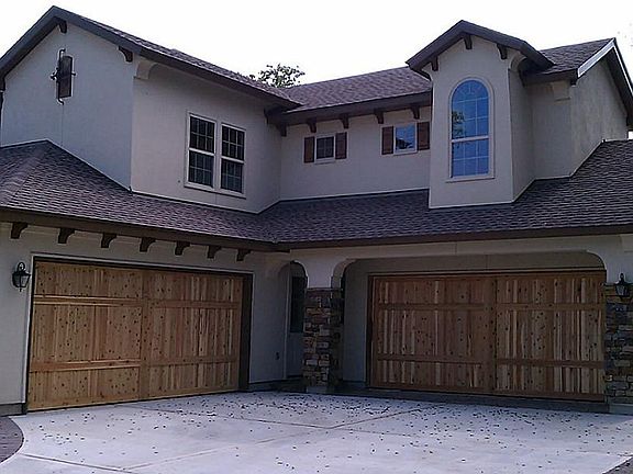 4 car garage with oversize wooden doors.