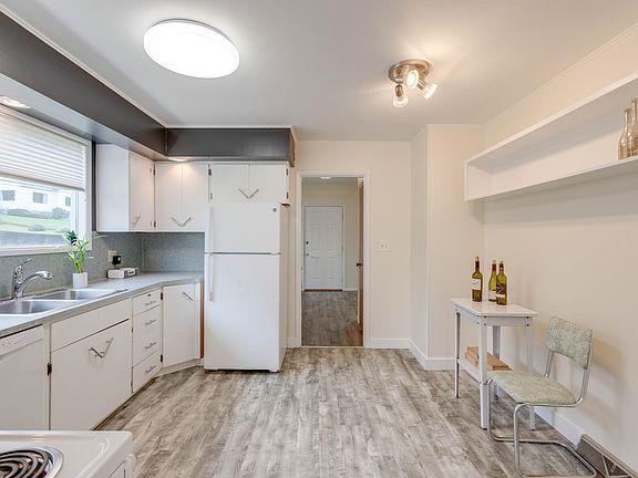 Kitchen adjacent to dining. Groceries come in from garage on interior stairway.