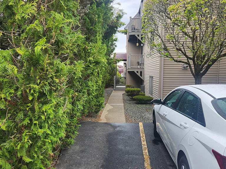 Back Entrance to unit # 64, deeded parking space right of white car