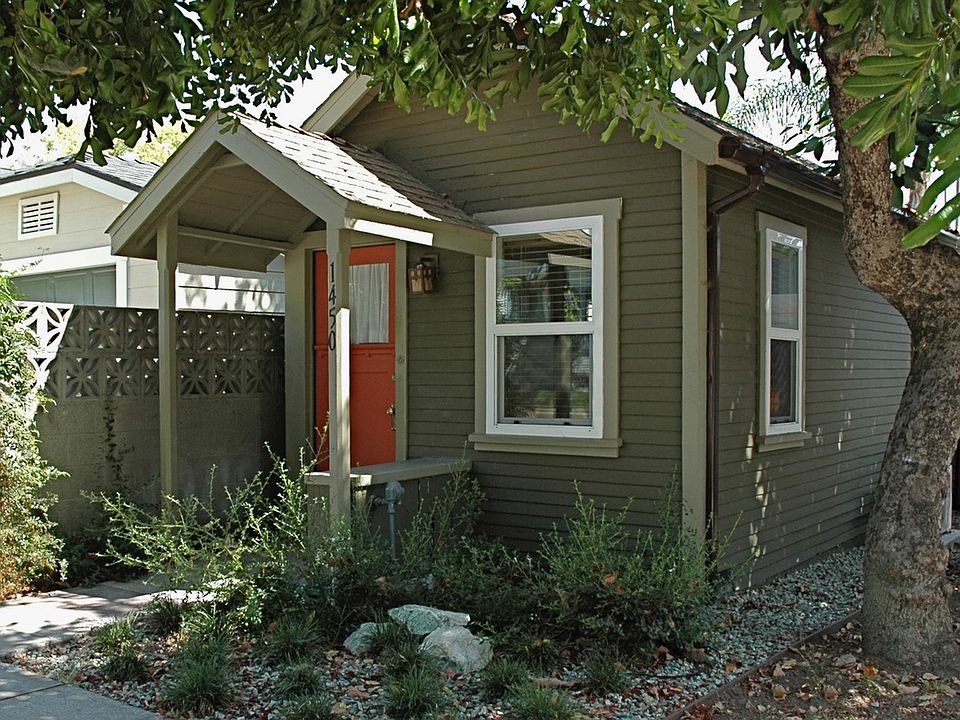 Front of house with covered seat and garden and two mature avocado trees. Street parking available in front of house.