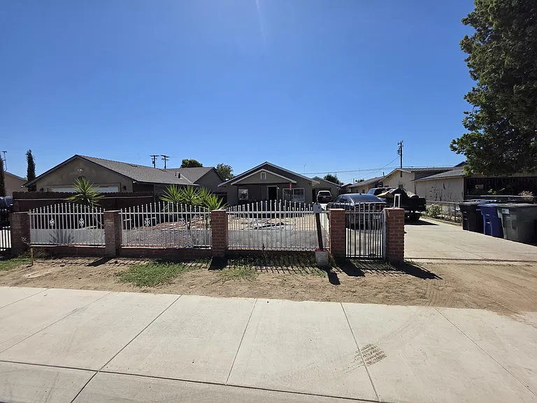 LARGE YARD WITH WROUGHT IRON FENCE AND ROLLING GAT.E YARD
COULD USE TLC.