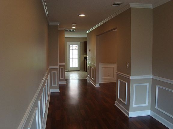 Standing just inside front door looking down entry hallway with den then dining room on the right.
