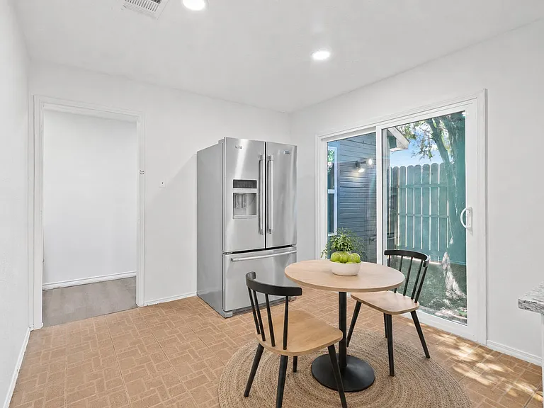 Breakfast nook with a bistro table set beside sliding glass doors, plus a stainless French-door refrigerator and easy patio a