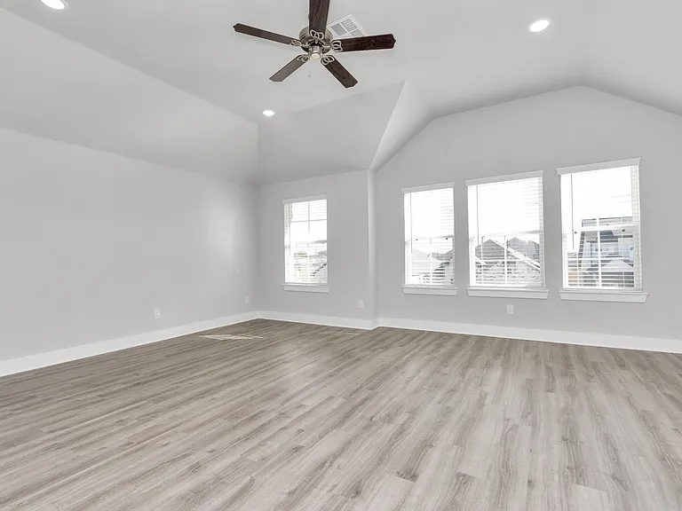 Spacious upstairs game room featuring high vaulted ceilings and abundant natural light from large windows