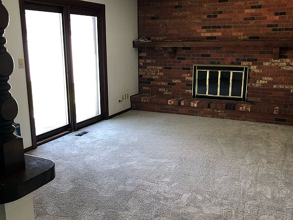 Family room view standing in dining area near kitchen. Pella sliding doors open to clean patio and large backyard