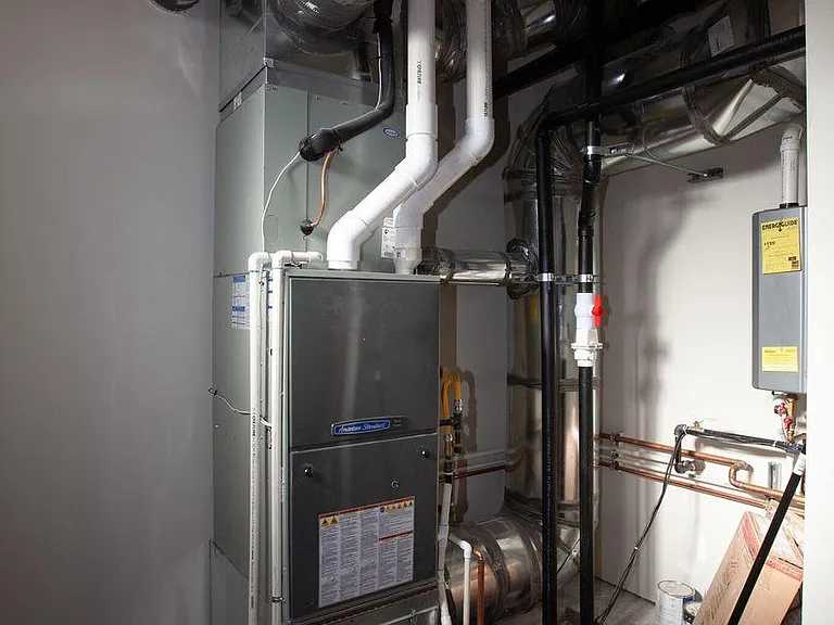 Utility room with new gas furnance, on-demand hot water heater, washer/dryer, new refrigerator and utility sink and counter