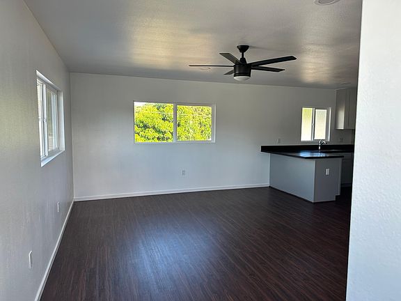 Living room area, attached to the kitchen. View of countertop with peninsula designed as an eat-in kitchen.