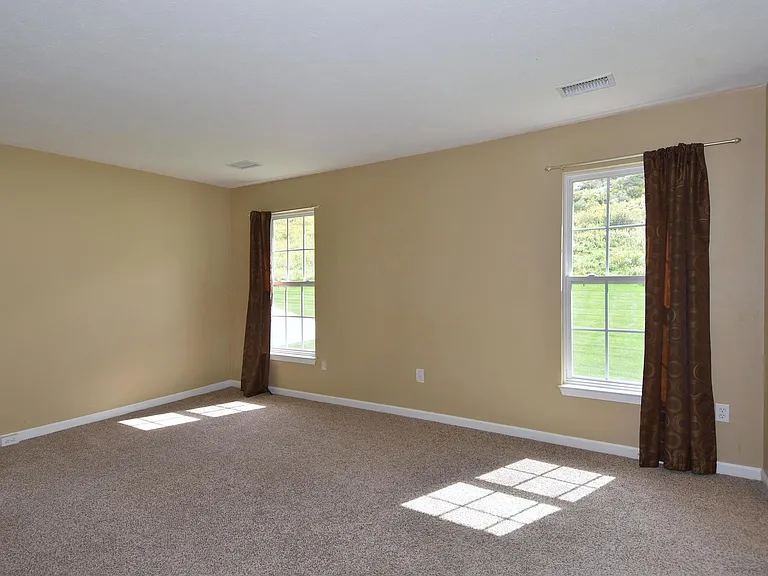 The master bedroom is huge with windows.