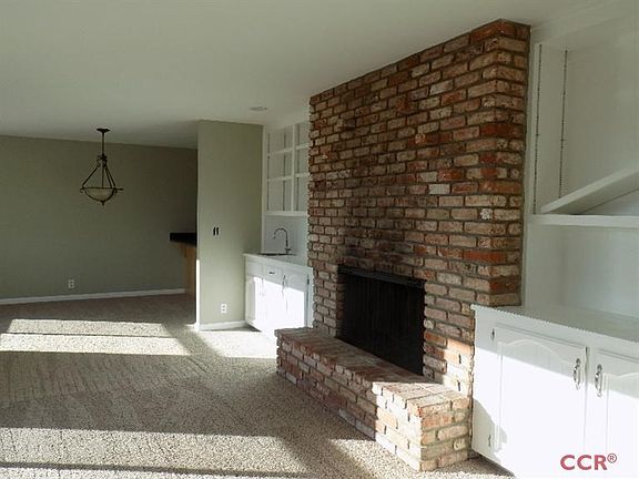 The front room has 2 large windows, brick wood burning fireplace, built in cabinets and wet bar. New carpet and paint.