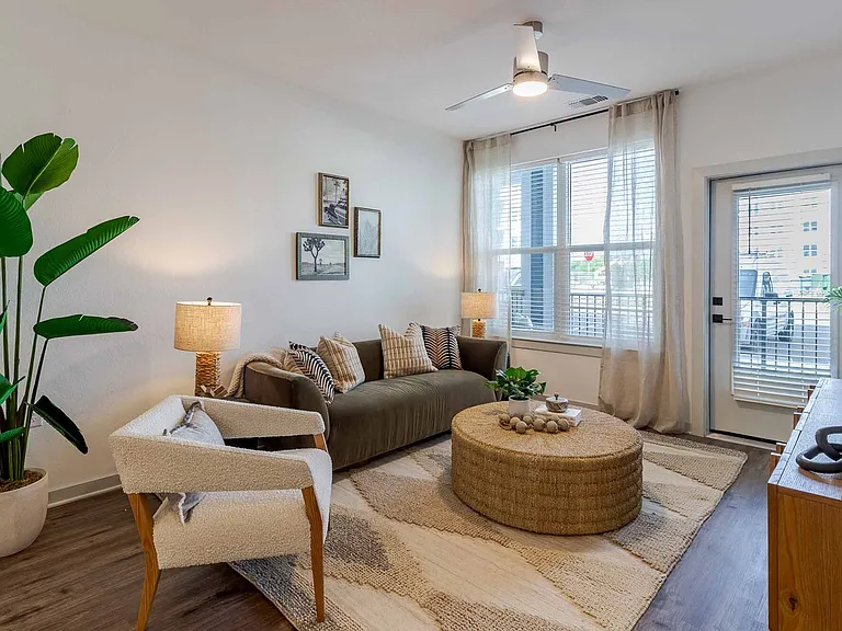 Sunlit living room with oversized windows and direct access to a private balcony. Sunlit living room with oversized windows and direct access to a private balcony.