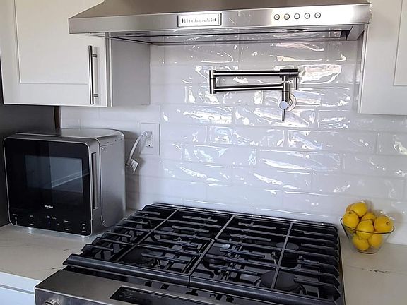 Upgraded Kitchen Amenities: 5 burner Gas Range and Oven, Over-Range Vent, and Pot Filler faucet.