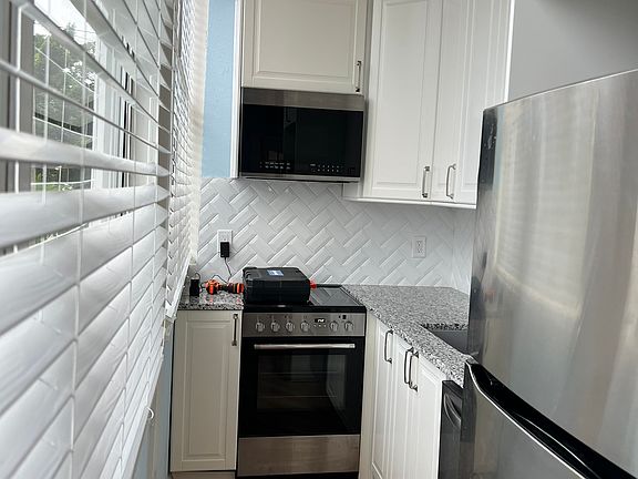 Kitchen has tall ceiling and wonderful big windows with views of the bay