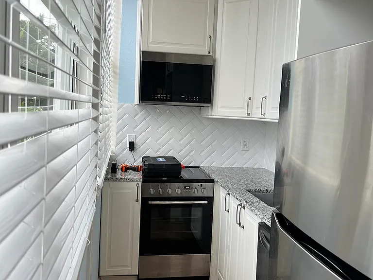 Kitchen has tall ceiling and wonderful big windows with views of the bay