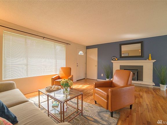 Large living room with beautiful hardwoods and brick fireplace with wood fireplace insert.  Coat closet too!