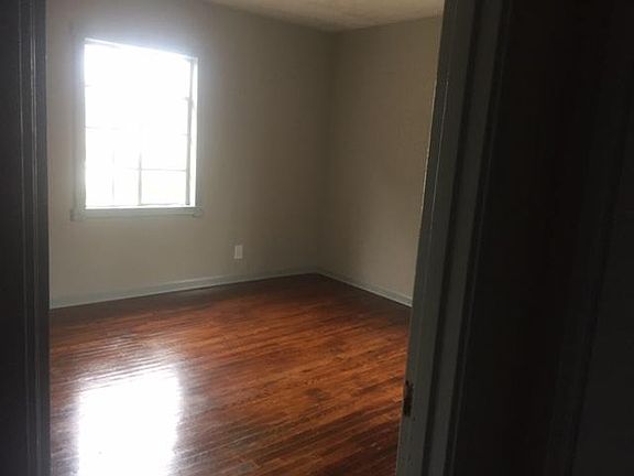 One of two large bedrooms with hardwood floors and plaster walls.