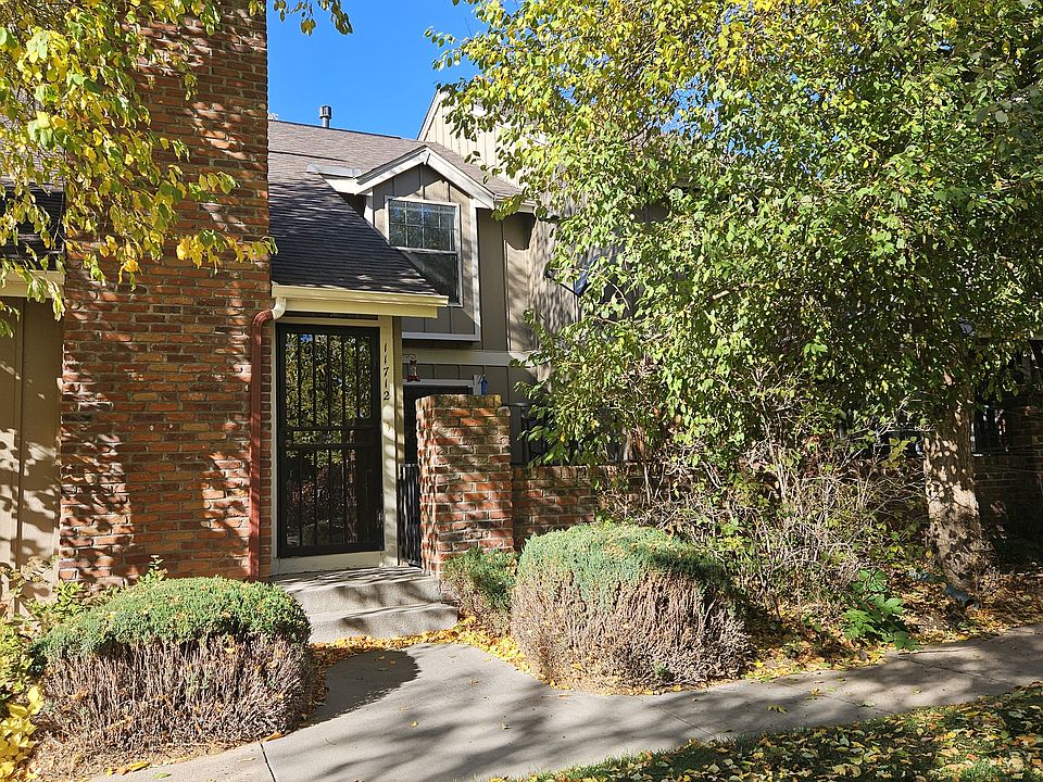 Entrance with mature, maintenance-free landscaping.