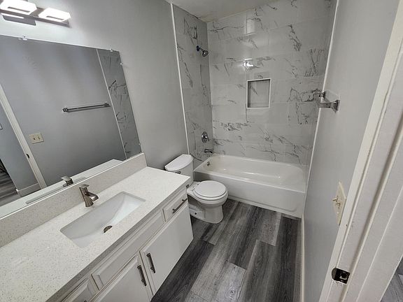 Newly renovated bathroom with laminate flooring and tiles