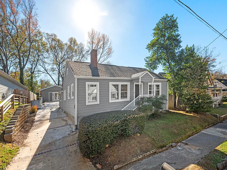 The front of the house showcases a picturesque scene, with a driveway leading to the back unit and a spacious parking pad that spans 60'.