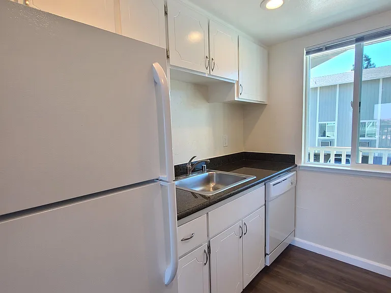 Galley Kitchen complete with Refrigerator, Dishwasher, and Garbage Disposal