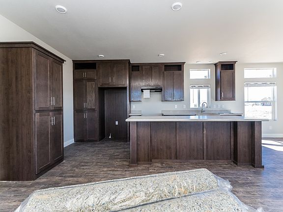Kitchen - Solid wood cabinets to ceiling, upgraded nickel hardware, title back splashes, highly upgraded stainless appliance package, large center island, and country farm sink with pull-out faucet, recessed lighting.
