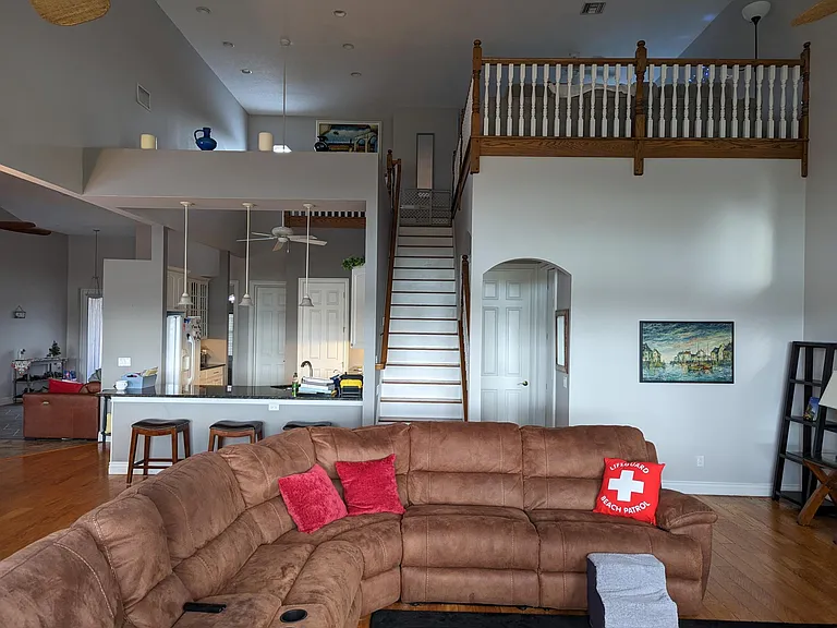 Living room, view from windows toward kitchen, stairs and second bedroom. Note: Bedroom #2 and its full bathroom are located underneath the loft area (bottom right in this photo)