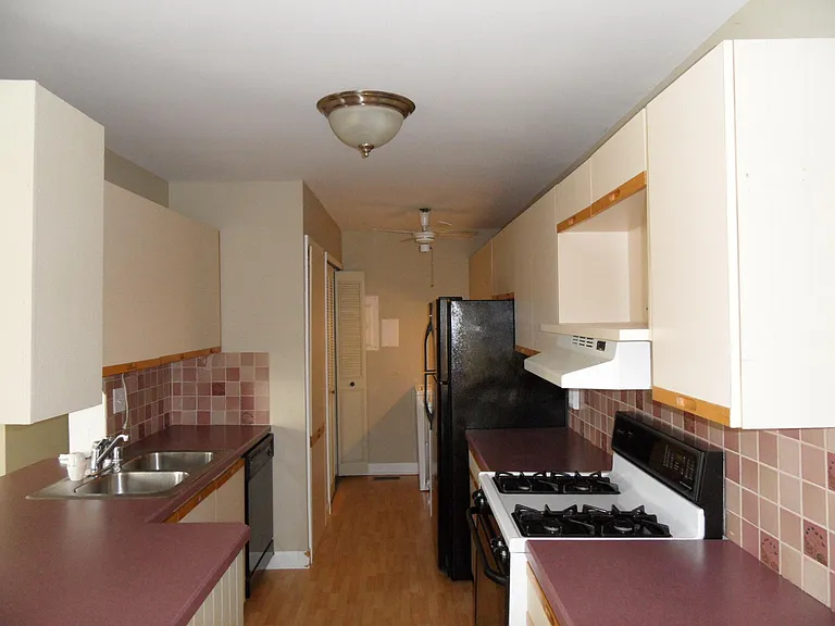 kitchen with gas stove, refrigerator, disk wash, washer and dryer behind the refrigerator