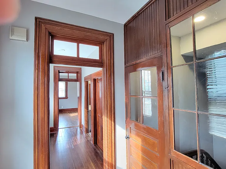 2nd floor entry hall with doors at top of staircase and window that opens overlooking staircase. View towards bedroom, bath and laundry.