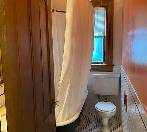 claw foot tub with tiled bathroom